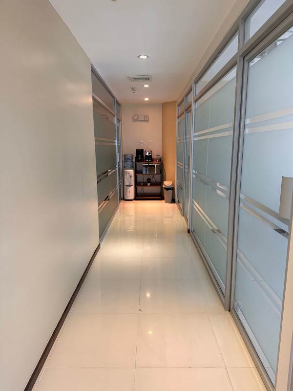 Office corridor with frosted glass partitions and cafeteria nook at Oceania Business Plaza Tower 1000