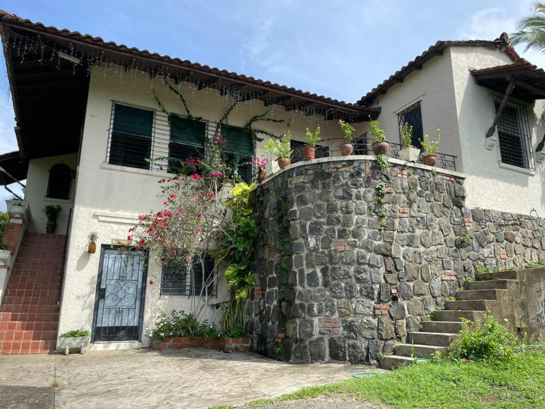 Exterior Spanish colonial house with arched staircase, terracotta roof, potted plants Las Cumbres Panama