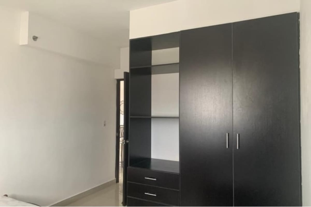 Bedroom with dark built-in wardrobe, tile flooring in Park Lefevre Panama apartment