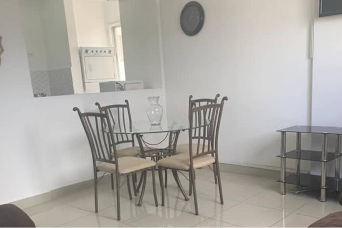 Dining area with glass table, open partition to kitchen and laundry zone Park Lefevre Panama apartment