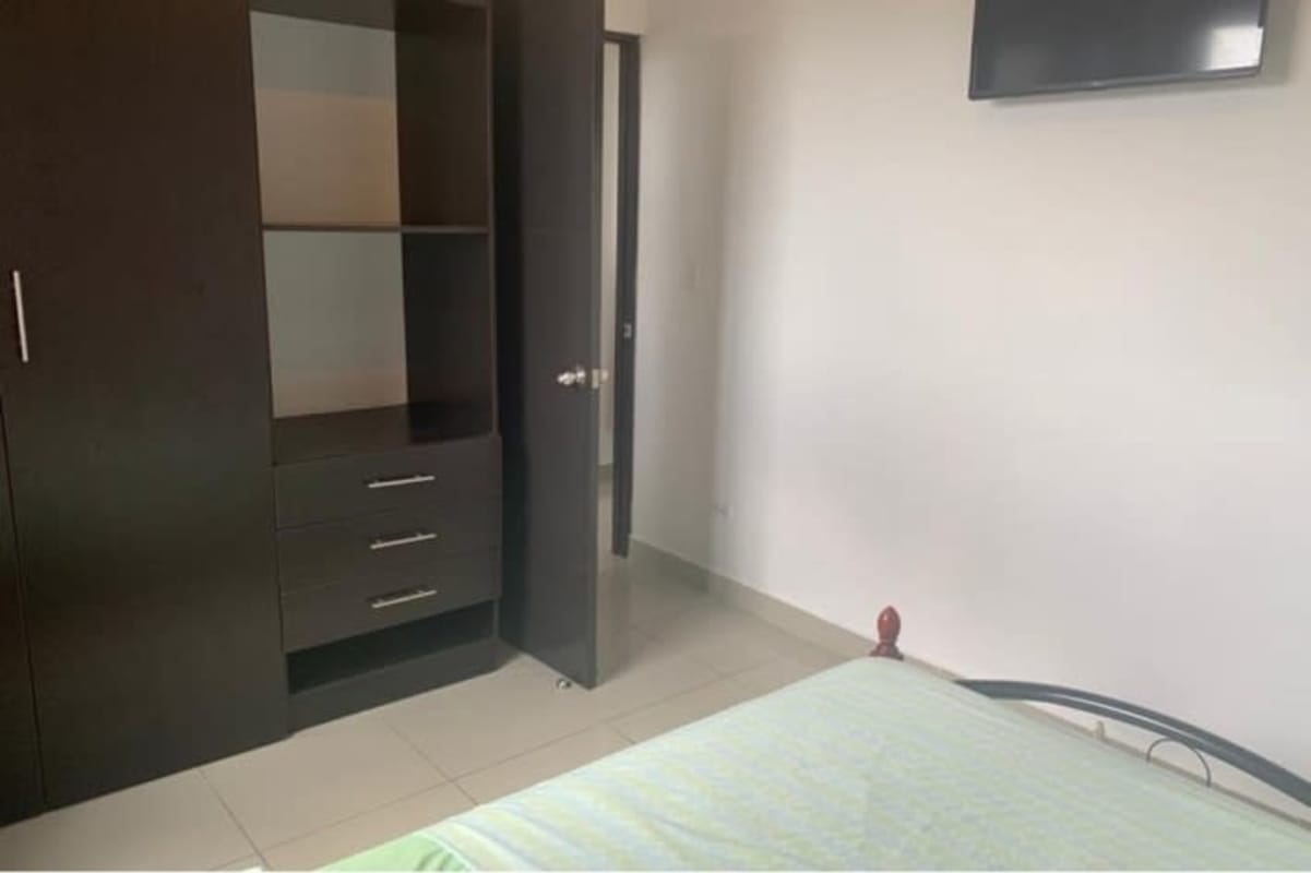 Bedroom with built-in wardrobe, green bedding, wall-mounted TV Park Lefevre Panama