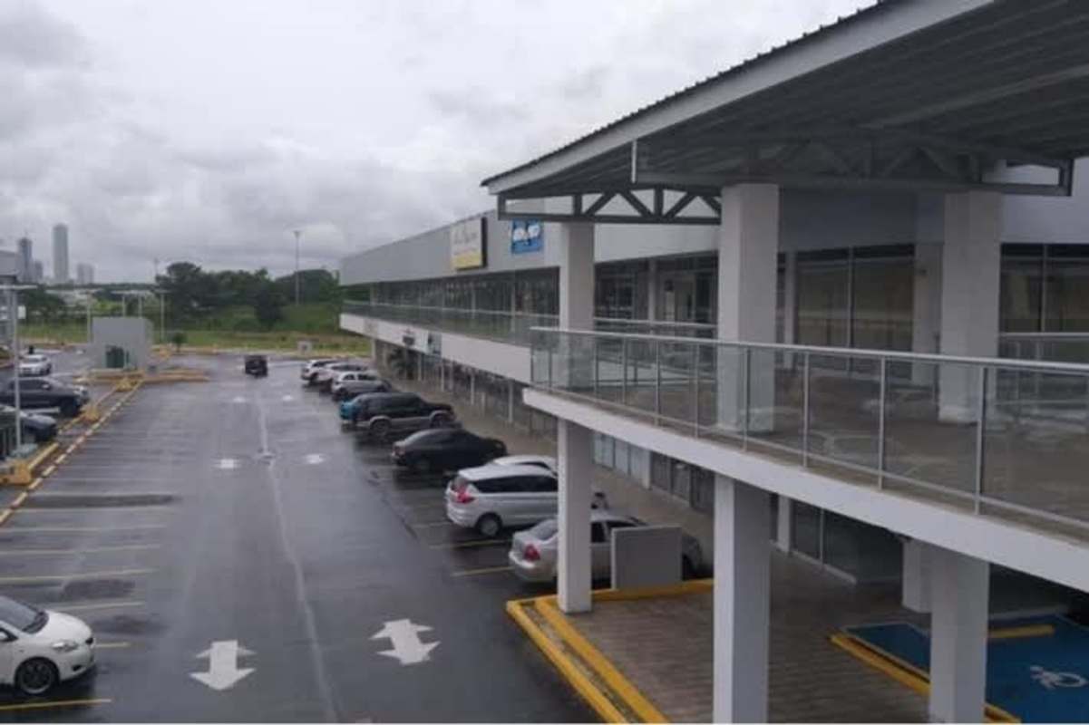 Main entrance and storefronts of Costa Sur commercial shopping center with vehicles Panama City