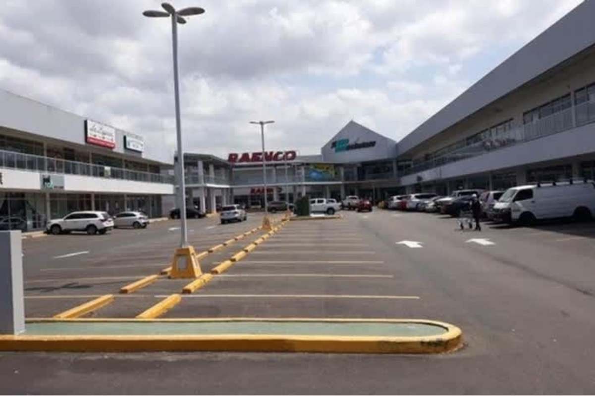 Glass balcony railings and facade detail at Costa Sur Commercial Plaza parking lot view Panama