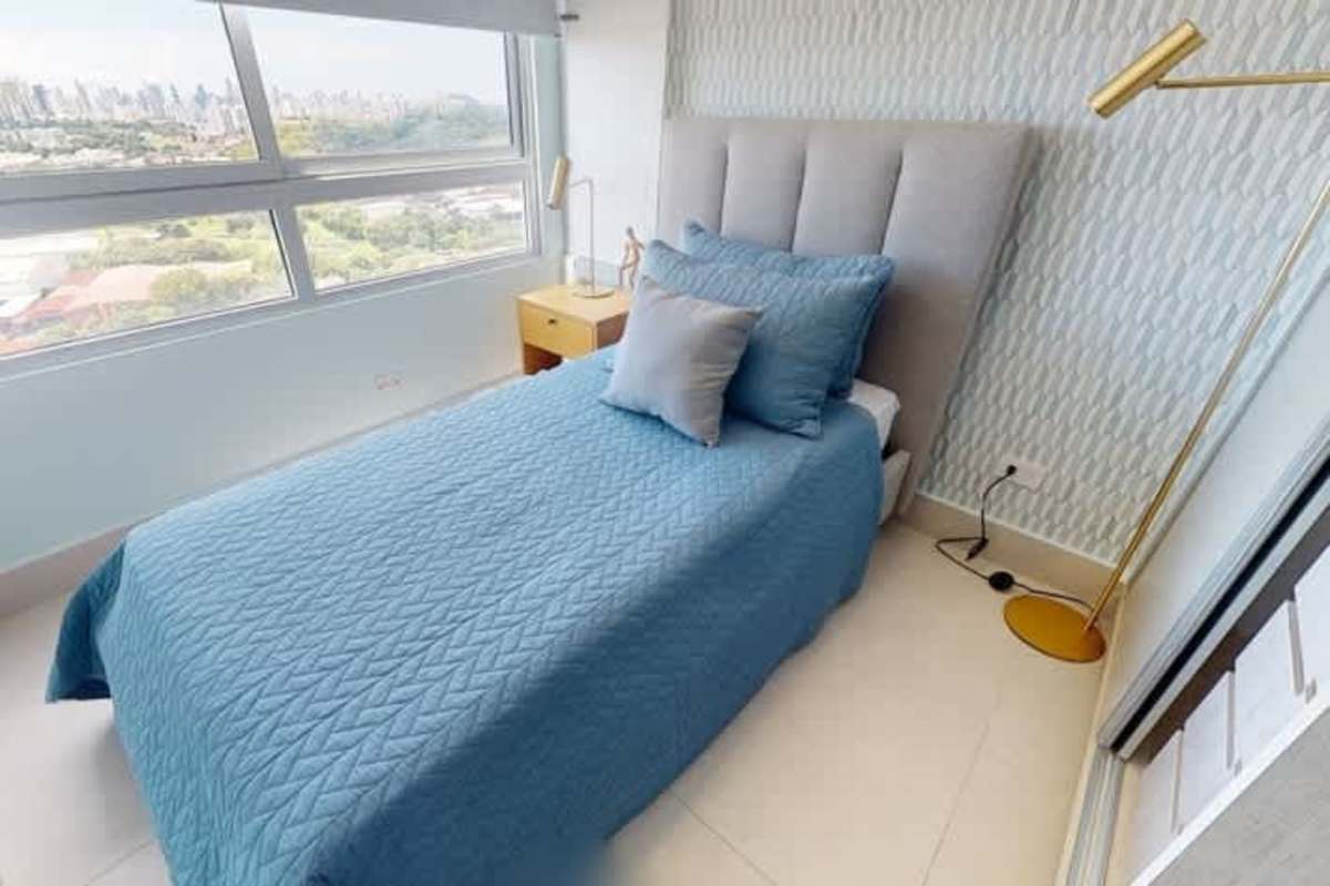 Bedroom with panoramic windows, blue bedding, accent wall PH Greenwood Tower in Panama City