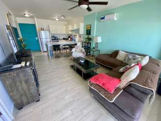 Open living space with sectional sofa and TV in The Sanctuary Playa Caracol Panama