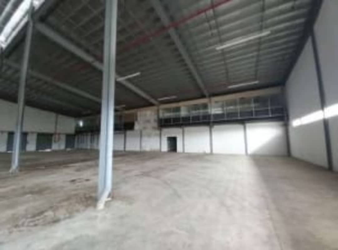 Empty high-ceiling warehouse with concrete floor steel beams Villas de Santa Barbara