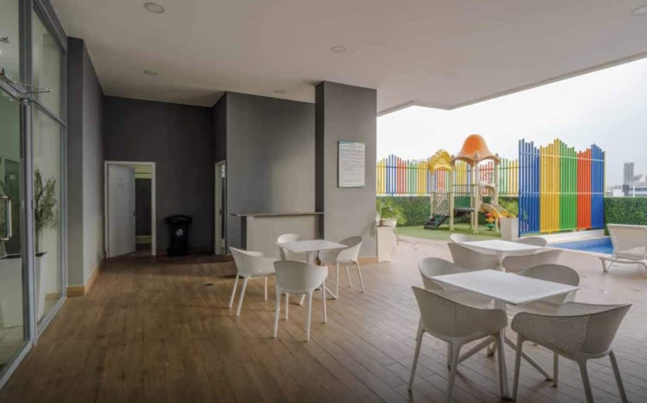 Covered social area with tables, playground and pool at PH Áthas 12 de Octubre Panama
