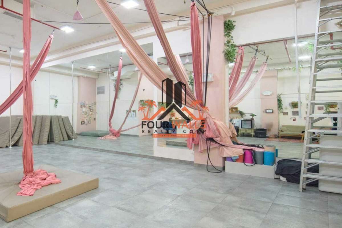 Interior aerial yoga commercial studio with pink silks, mirrors, industrial lights Balboa Boutiques Panama City