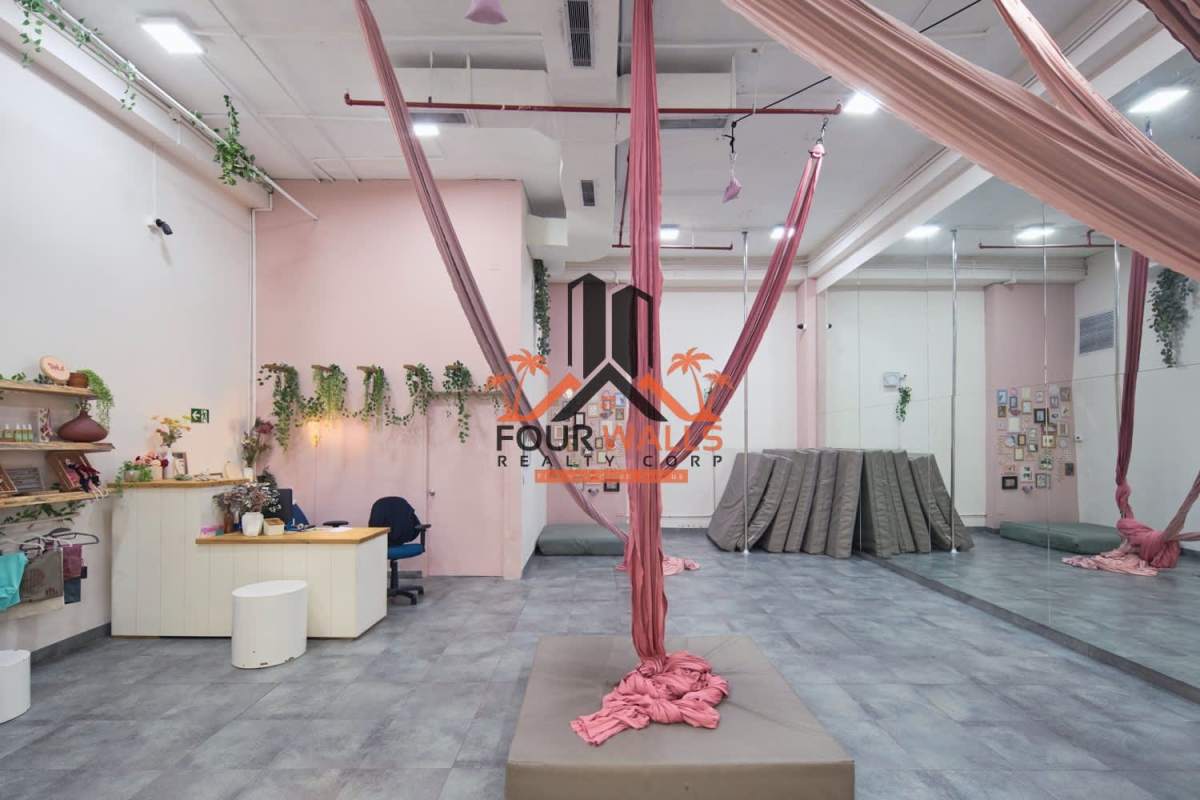 Aerial yoga studio with pink silks, mirrors, soft mat flooring, reception area Balboa Boutiques Strip Mall