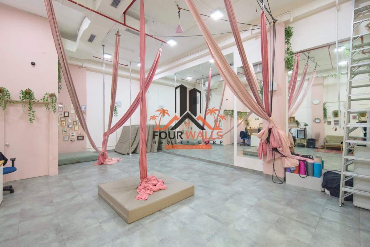 Minimalist bright commercial studio with reception desk, pink aerial hammocks and mirrors in Balboa Boutiques Panama