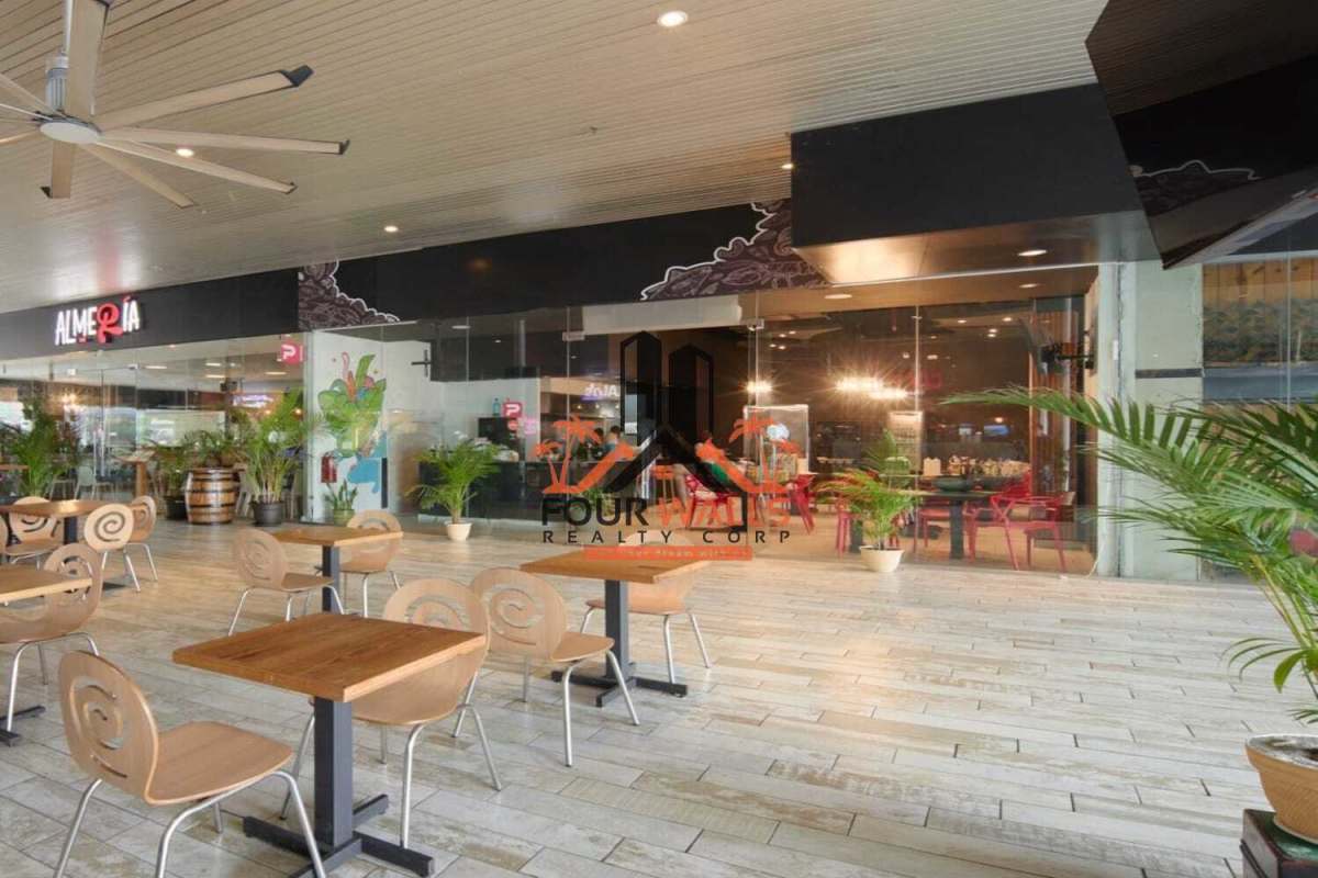 Open indoor dining area with plants and wooden chairs in Panama strip mall for lease