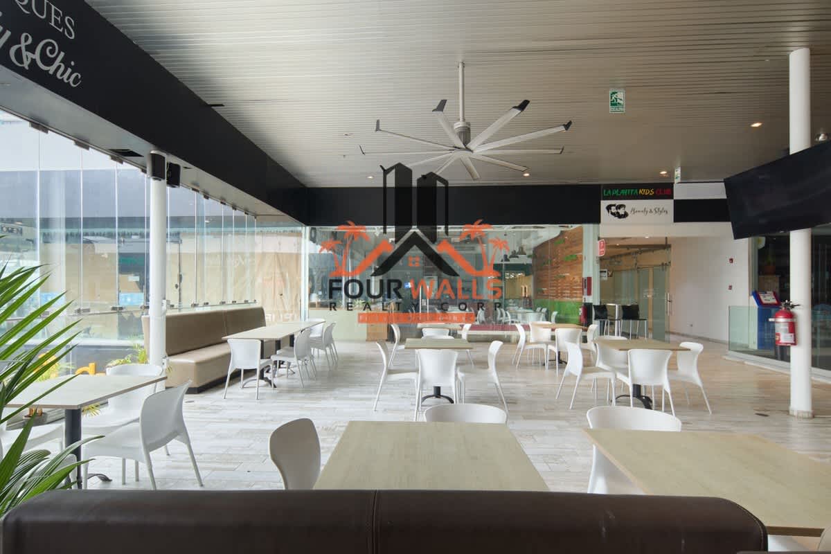 Commercial dining space with white chairs, glass walls, ceiling fan at Avenida Balboa Panama