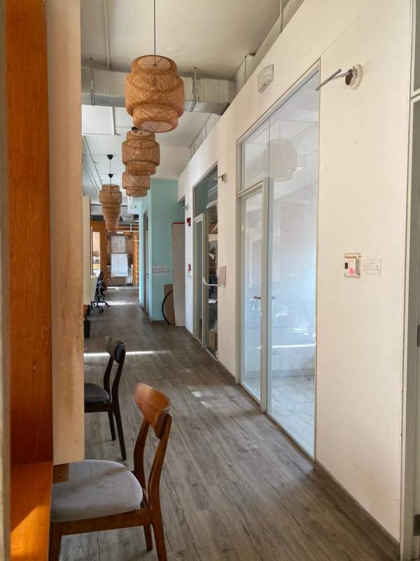 Office corridor with wood floors, pendant lights and glass cubicles in Casco Viejo Panama