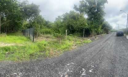 Gravel roadside view next to fenced large acreage development land near Coronado beach Panama
