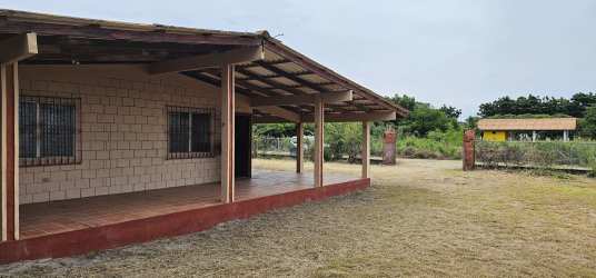 Spacious covered terrace patio of beach house in Punta Chame with brick walls and yard view