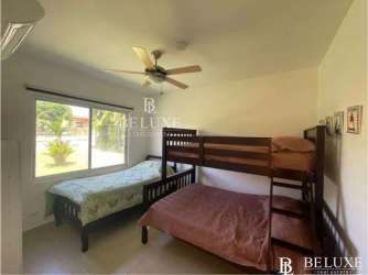 Open plan living-dining area with AC, ceiling fans and garden view in Nueva Gorgona beach house Panama