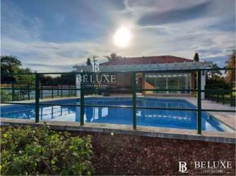 Front view with garden and driveway of the beach house for sale in Nueva Gorgona Panama