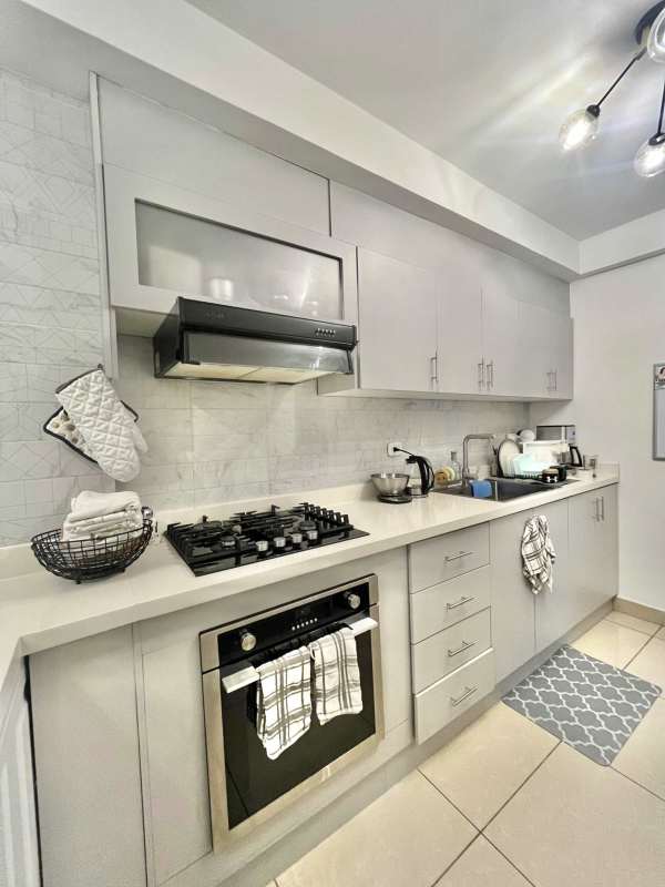 Kitchen with modern cabinetry, appliances, tiled backsplash in PH San Francisco Bay Tower 500 Panama