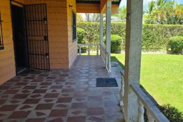 Covered patio terrace overlooking swimming pool and tropical backyard at Panama Coronado beach home