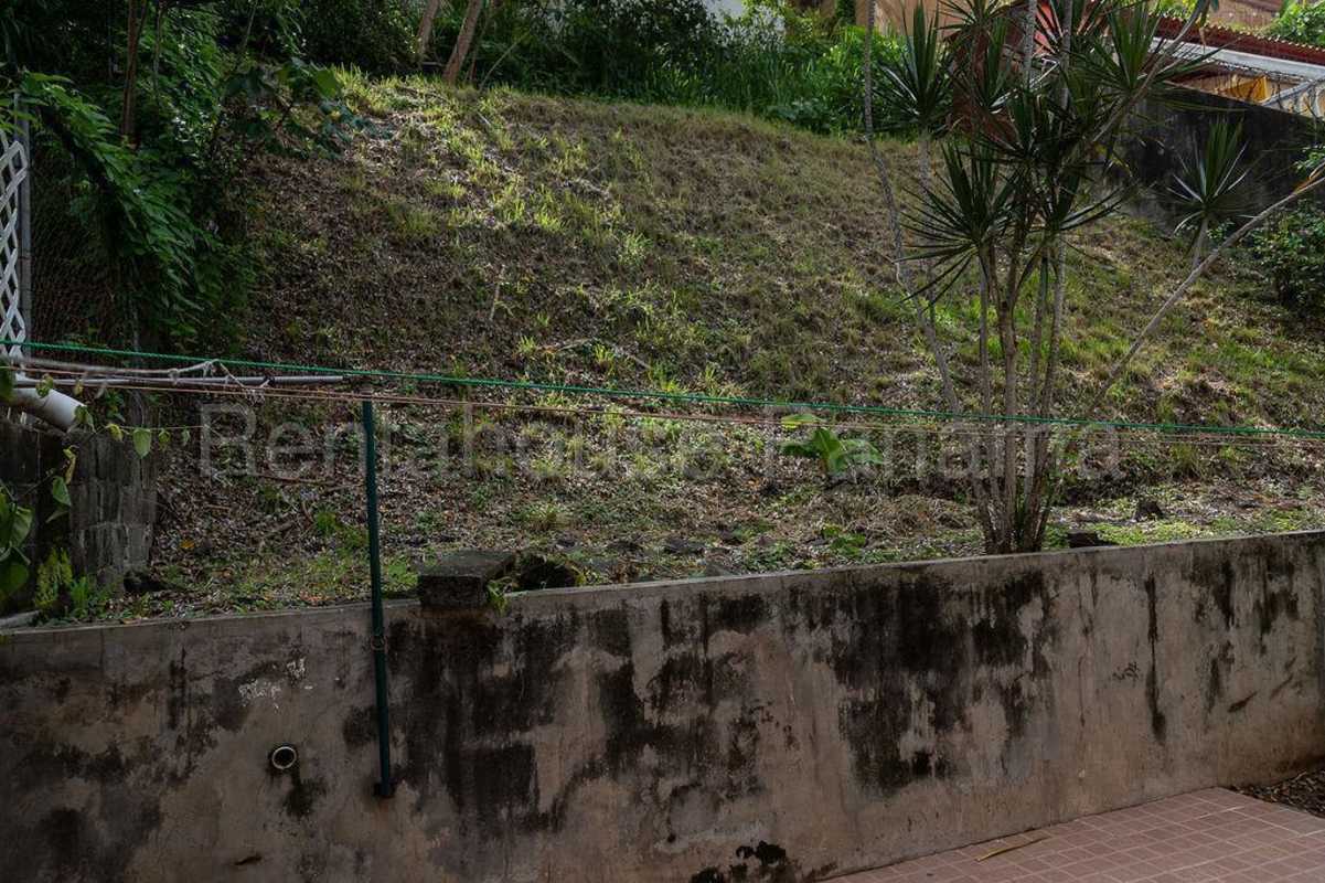 Dining room with six-seater table, wall-mounted TV, and window with natural light in duplex house Panama