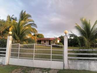 Gated tropical home with palm trees, fenced yard, single story villa in Las Lajas Chame Panama