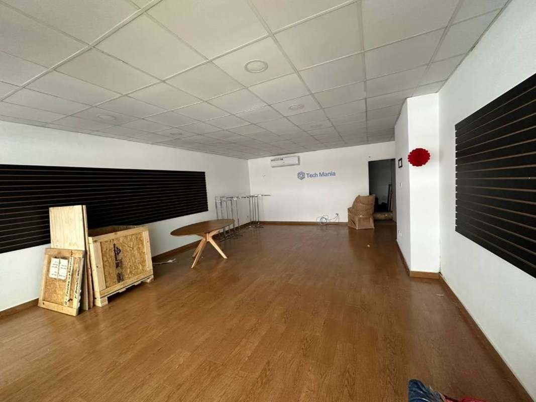 Exterior of commercial strip with Tech Mania store, barber shop, cars and street view in Obarrio Panama