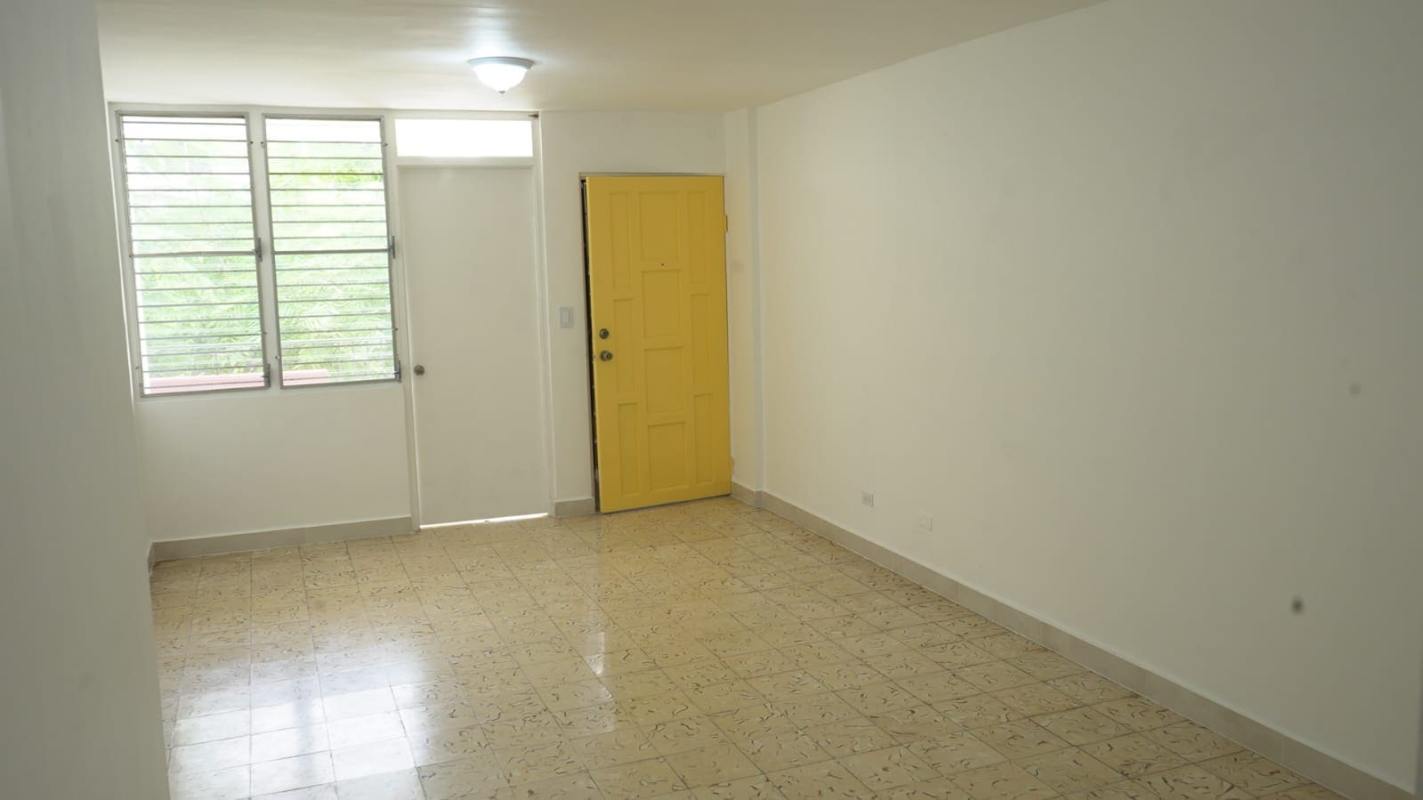 Bright living room yellow door large windows balcony view PH Trébol Panama City