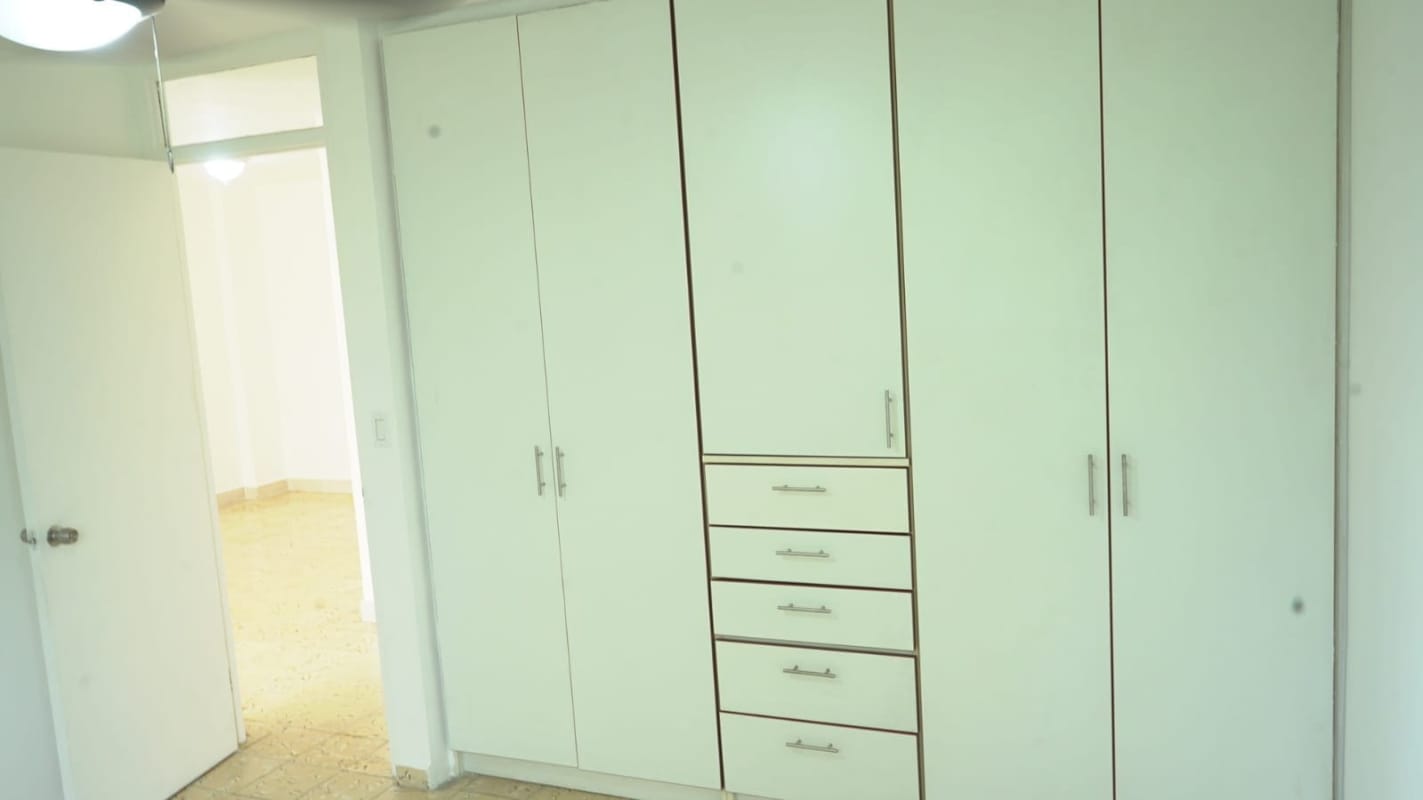 Bedroom with large built-in wardrobe open door tile floor at PH Trébol Panama City