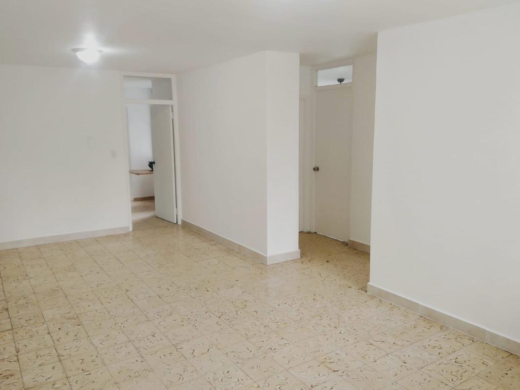 Empty living area with tile floors, white walls and multiple doorways in PH Trébol Parque Lefevre