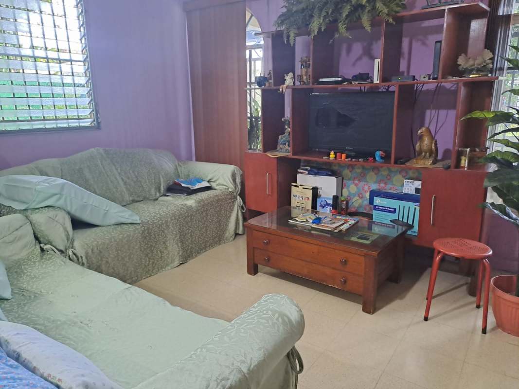 Traditional living room with sofas, entertainment center, and lavender walls house for sale Villa de las Fuentes Panama