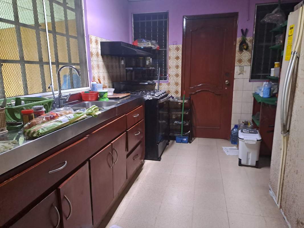Kitchen with wooden cabinetry, stainless countertop, gas stove in Villa de las Fuentes Panama