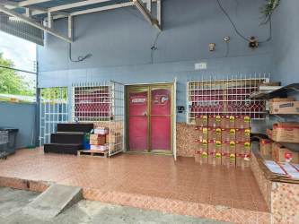 Commercial storefront with tiled platform, metal bars, and pink double doors in Terronal commercial area David Chiriquí