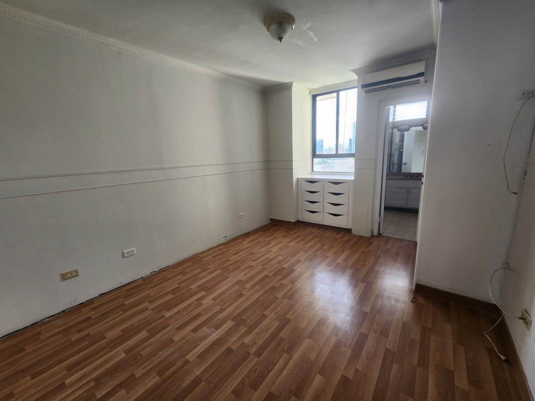 Spacious bedroom with wood flooring large windows city skyline view built-in closet in PH Paitilla Penthouse Panama