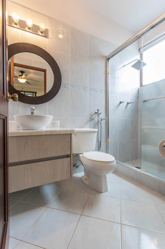 Contemporary bathroom with vessel sink, glass-enclosed shower in luxury Camino de Cruces house Panama