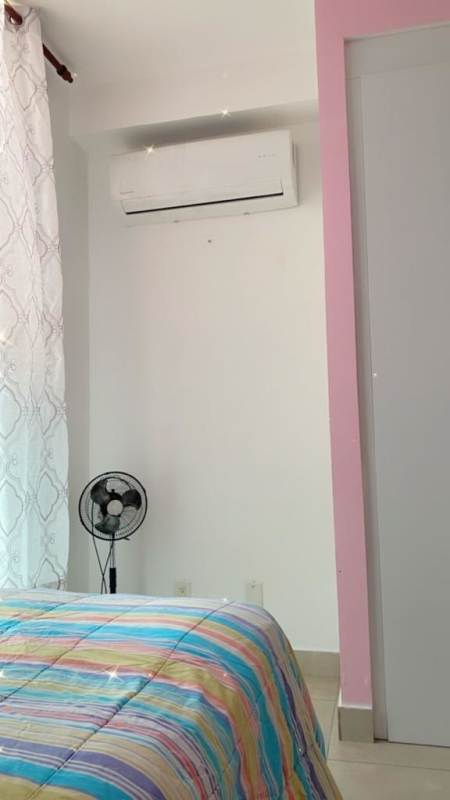 Bedroom with pink accent wall, AC, and closet in Carrasquilla Towers rental Panama