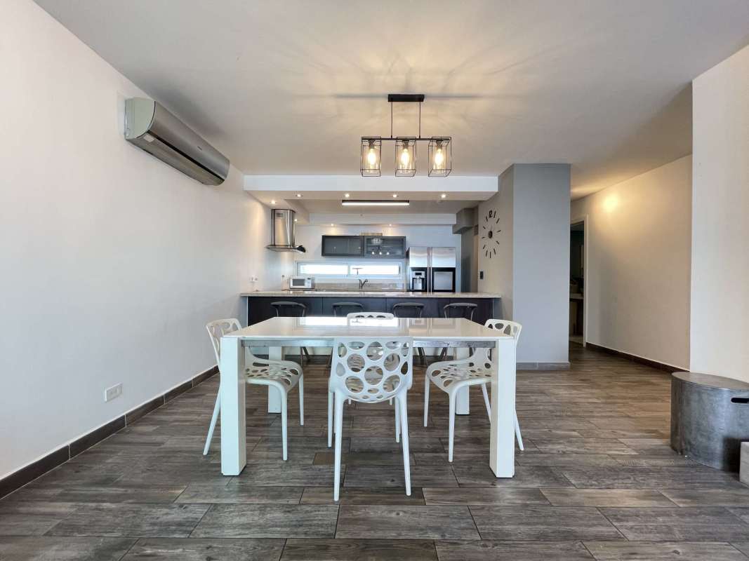 Living and dining room with large windows and balcony access with ocean view PH Nautica Panama