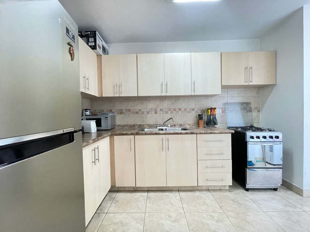 Contemporary kitchen with granite counters, wood cabinets, and appliances in PH Marquis Tower El Cangrejo