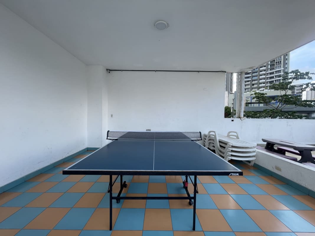 Covered outdoor lounge with ping pong and seating overlooking city in PH Marquis Tower El Cangrejo