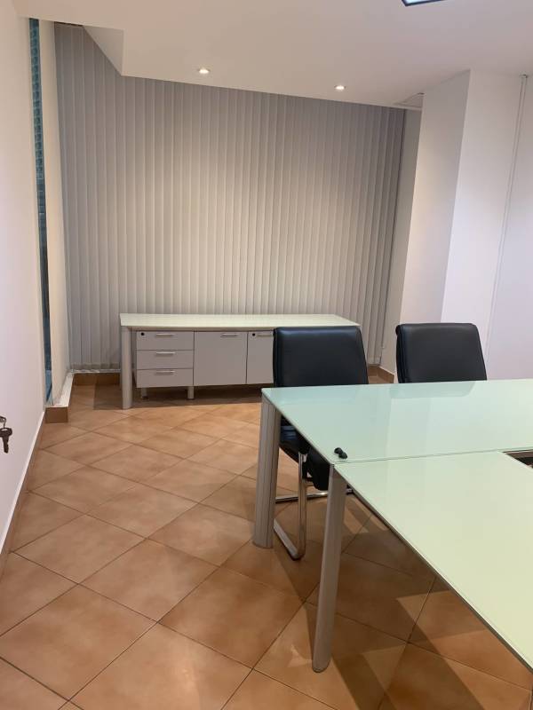 Workspace area with glass desk and blinds at PH Omega Obarrio Panama