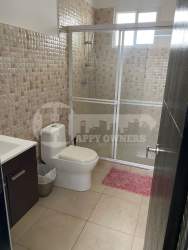 Dining area with glass table, six chairs, TV, large window and open kitchen Paradise Point Panama