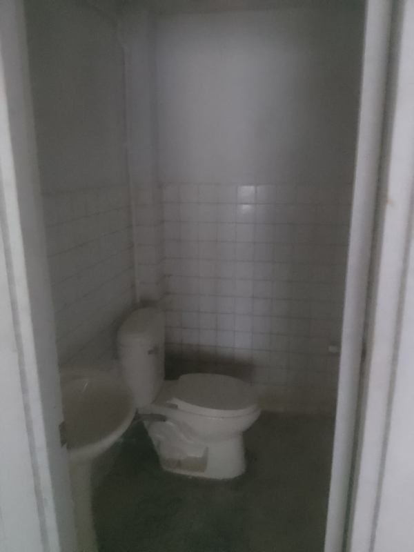 Minimalist bathroom with white tiles and fixtures inside commercial unit in Santa Ana Panama