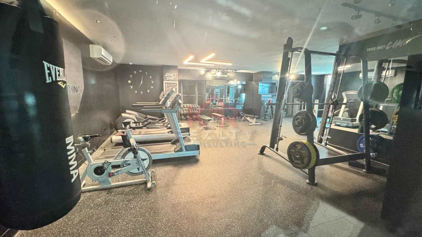 Large outdoor swimming pool with sun terrace lounge chairs high-rise tower