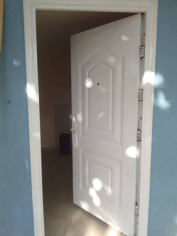 White security door set in blue wall entry of Río Abajo apartment Panama City