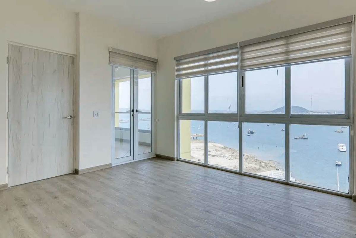Bedroom or living area with floor to ceiling glass, wood floors and ocean view balcony Causeway Towers Amador Panama