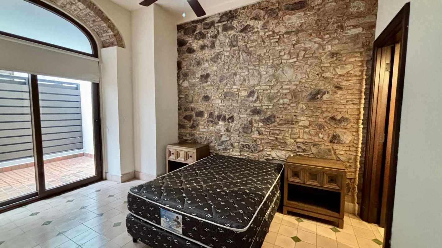 Bedroom with exposed stone accent wall and patio access Casco Viejo Panama