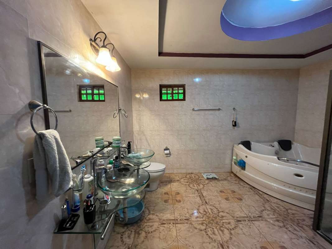 Kitchen with white tiles, cabinets, stove and fridge Villa de Las Fuentes Panama City