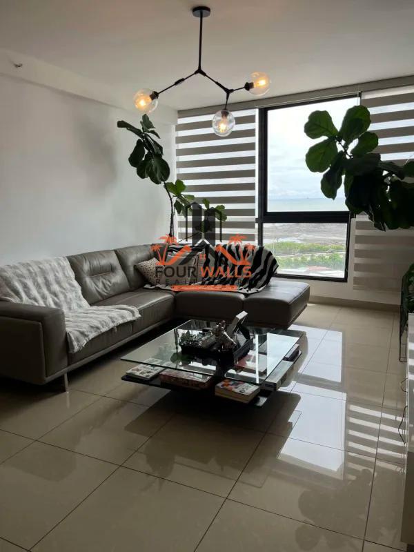 Modern furnished living room with sectional sofa, large window and city views in PH San Francisco Bay Panama City