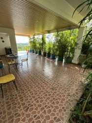 Covered terrace with tile floor, seating and garden view Chorrera home