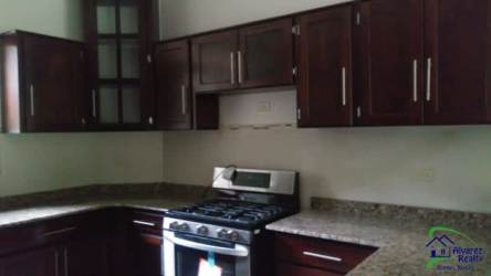 Contemporary kitchen with granite countertops, stainless steel gas stove and wooden cabinets in Las Villas Volcán
