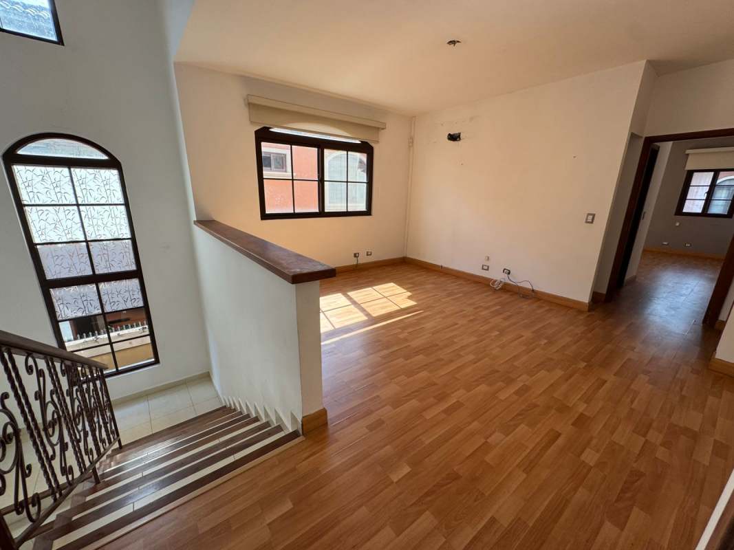 Double-height foyer with iron staircase and tile floors in Costa Sur house Panama